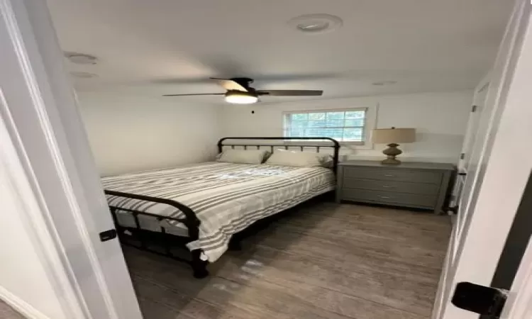 Bedroom with ceiling fan and laminate type flooring