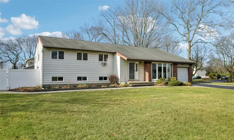 View of front facade featuring a front lawn and a garage