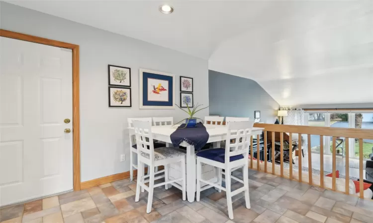 Carpeted living room featuring beam ceiling, a baseboard radiator, plenty of natural light, and a wall mounted AC