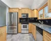 Kitchen featuring sink, appliances with stainless steel finishes, and dark stone counters