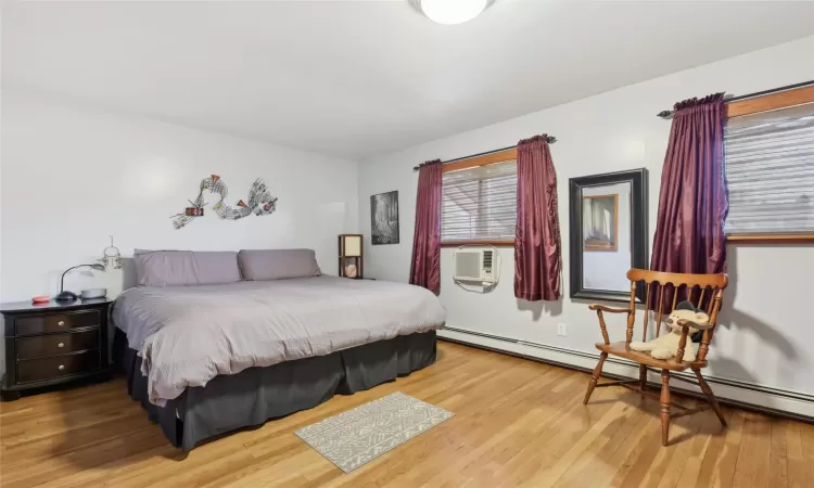 Full bathroom featuring vanity, combined bath / shower with glass door, tile patterned flooring, toilet, and baseboard heating