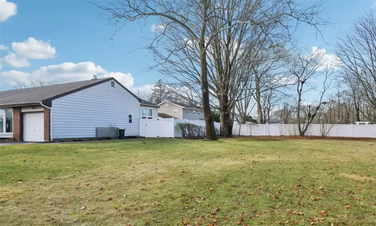 View of property exterior with a wall unit AC, a covered pool, and a lawn