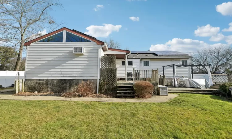 Rear view of property with a deck and solar panels