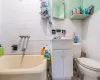 Bathroom featuring toilet, decorative backsplash, a bathtub, vanity, and tile walls