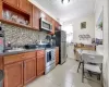 Kitchen featuring crown molding, sink, decorative backsplash, appliances with stainless steel finishes, and light tile patterned flooring