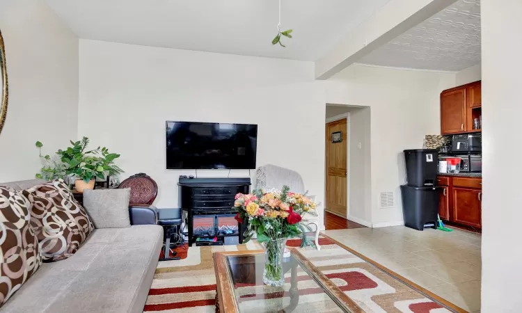 Living room with beam ceiling and light tile patterned floors