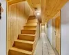 Stairs featuring tile patterned flooring, wooden ceiling, and wood walls