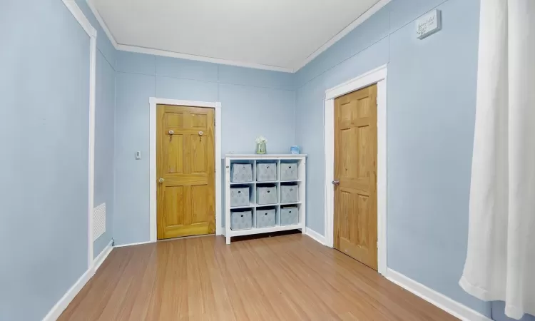 Spare room featuring hardwood / wood-style floors and crown molding