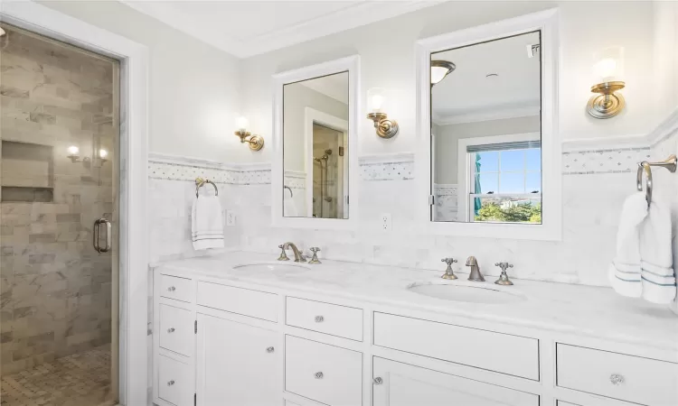 Bathroom featuring vanity, an enclosed shower, ornamental molding, and tile walls