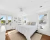 Bedroom with ceiling fan, dark wood-type flooring, access to outside, and multiple windows