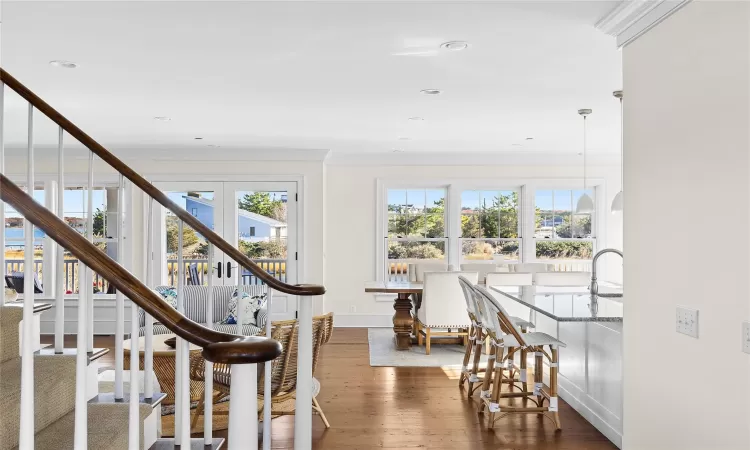 Staircase with wood-type flooring, french doors, and crown molding