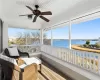 Sunroom / solarium featuring wooden ceiling, a water view, ceiling fan, and a healthy amount of sunlight