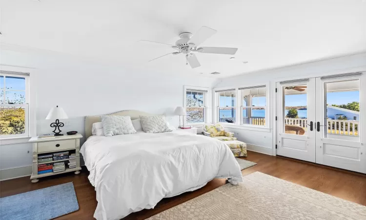 Bedroom featuring access to exterior, ceiling fan, dark hardwood / wood-style flooring, a water view, and ornamental molding