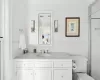 Bathroom with vanity, a shower with door, toilet, ornamental molding, and tile walls