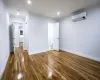 Spare room featuring dark hardwood / wood-style floors, a wall mounted AC, and ornamental molding