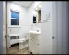 Bathroom featuring vanity, toilet, and radiator heating unit