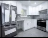 Kitchen with white cabinetry, stainless steel appliances, and tasteful backsplash