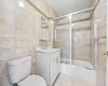 Full bathroom featuring vanity, tile patterned flooring, toilet, enclosed tub / shower combo, and tile walls