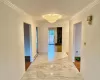 Corridor with crown molding, a baseboard heating unit, and a notable chandelier