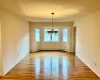 Spare room with light hardwood / wood-style flooring, baseboard heating, and a notable chandelier