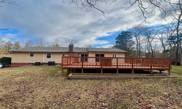 Back of house with central AC and a deck