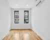 Unfurnished room featuring an AC wall unit and light hardwood / wood-style flooring