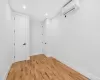 Unfurnished room with light hardwood / wood-style floors and a wall unit AC