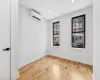 Unfurnished room featuring a wall mounted air conditioner and light wood-type flooring