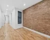 Unfurnished room with light hardwood / wood-style floors and brick wall