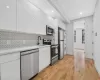 Kitchen featuring white cabinetry, sink, stainless steel appliances, and stacked washer and dryer