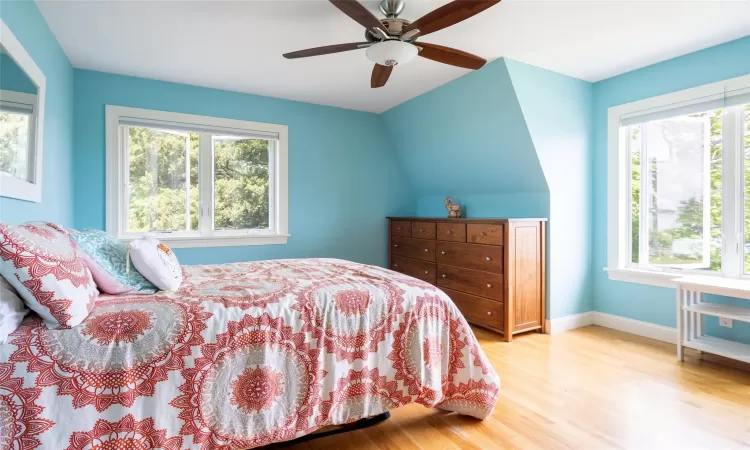 Bedroom featuring ceiling fan, light hardwood / wood-style flooring, and vaulted ceiling