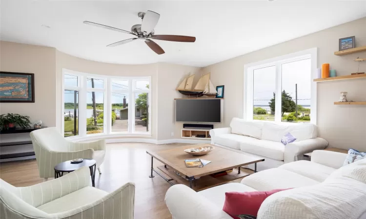 Living room featuring ceiling fan and light hardwood / wood-style flooring