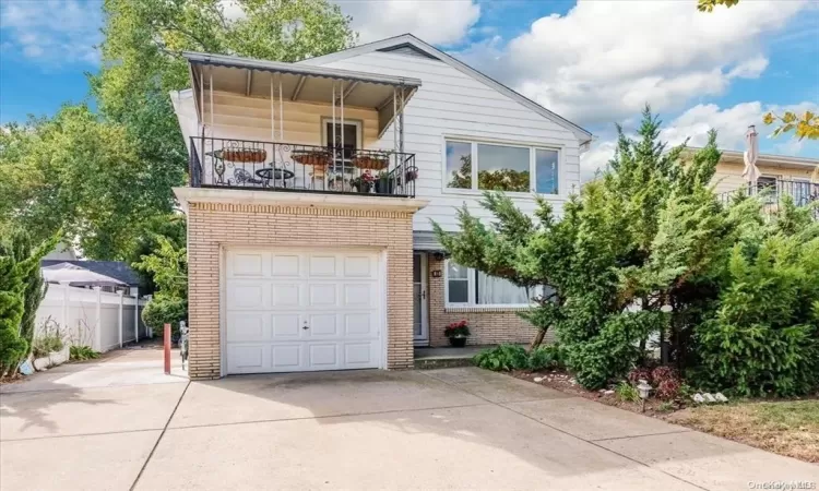 View of front of house with a balcony and a garage