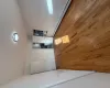 Unfurnished bedroom featuring baseboard heating, connected bathroom, and light hardwood / wood-style flooring