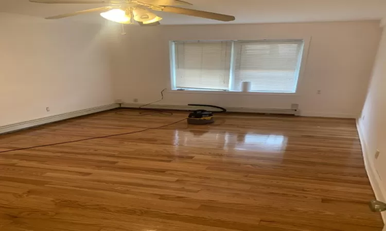 Empty room featuring hardwood / wood-style flooring, ceiling fan, and plenty of natural light