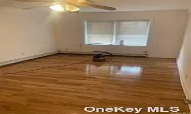 Empty room with hardwood / wood-style flooring