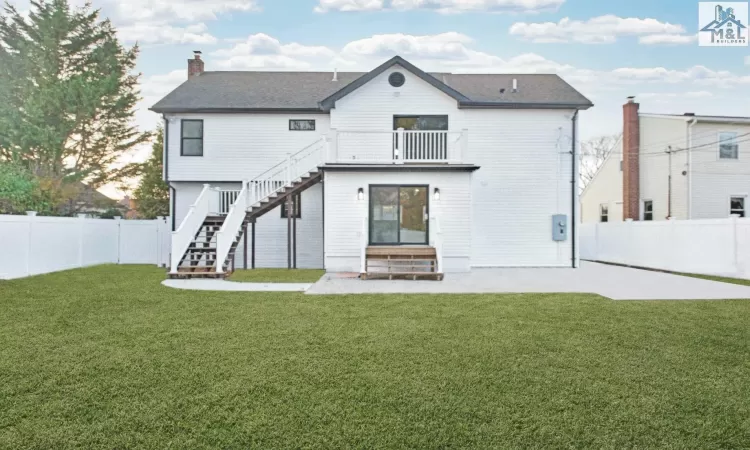 Rear view of house featuring a lawn and a balcony