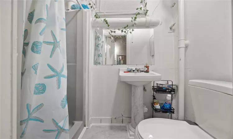 Bathroom featuring sink, toilet, and walk in shower