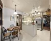 Kitchen with crown molding, sink, pendant lighting, cream cabinetry, and stainless steel fridge with ice dispenser