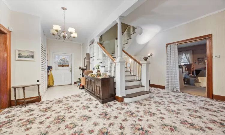 Foyer with a chandelier and ornamental molding