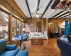 Living room featuring beamed ceiling, hardwood / wood-style flooring, ceiling fan, and a healthy amount of sunlight