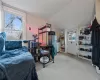 Bedroom with light colored carpet, vaulted ceiling, and fridge