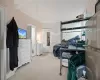 Bedroom featuring stainless steel refrigerator, carpet, and ornamental molding