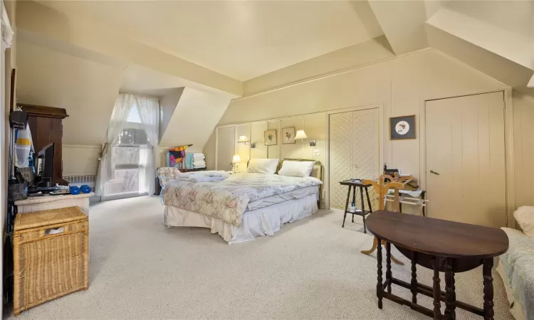 Bedroom with carpet floors and vaulted ceiling