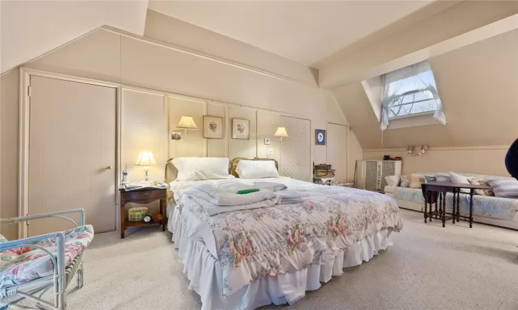 Carpeted bedroom with lofted ceiling