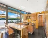 Kitchen with sink, wall chimney exhaust hood, a kitchen island, backsplash, and a water view