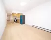 Kitchen with black refrigerator, stainless steel stove, a baseboard radiator, and light wood-type flooring