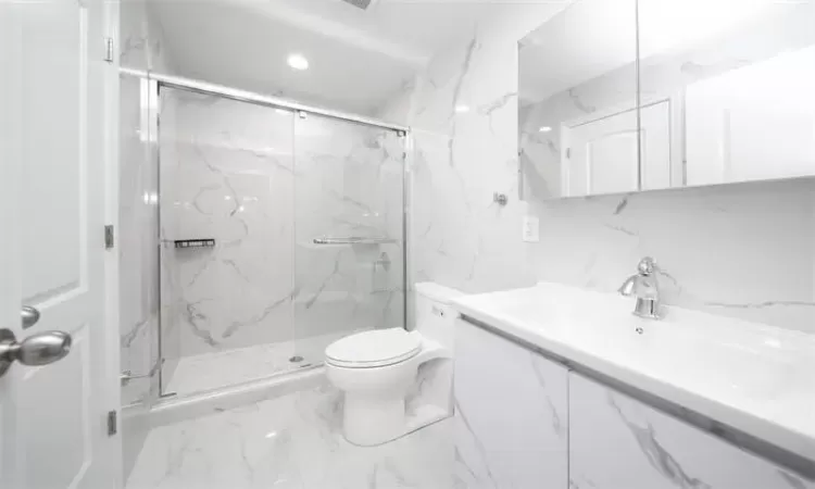 Bathroom featuring tasteful backsplash, toilet, vanity, and walk in shower