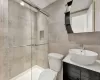 Bathroom with vanity, toilet, tile walls, walk in shower, and tasteful backsplash