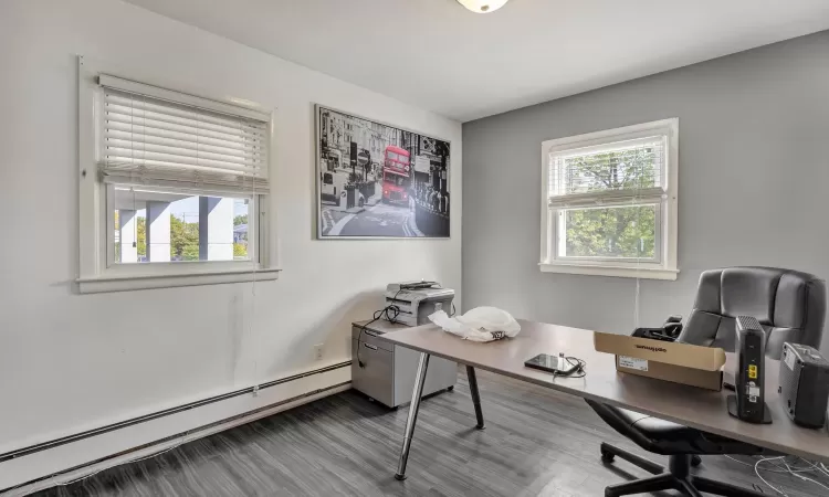 Home office featuring a baseboard radiator and hardwood / wood-style flooring